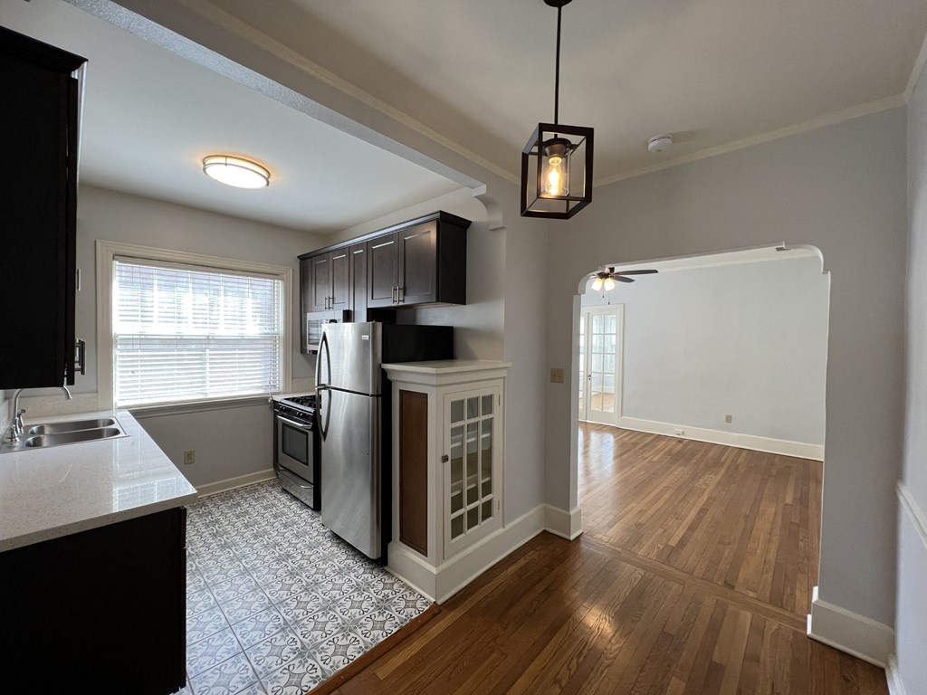 an empty kitchen and living room with a refrigerator and a sink