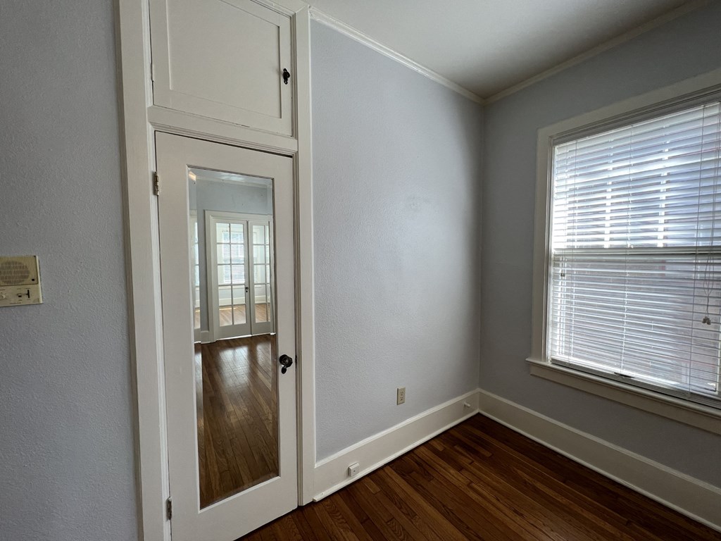 the bedroom of a house with a door and a window