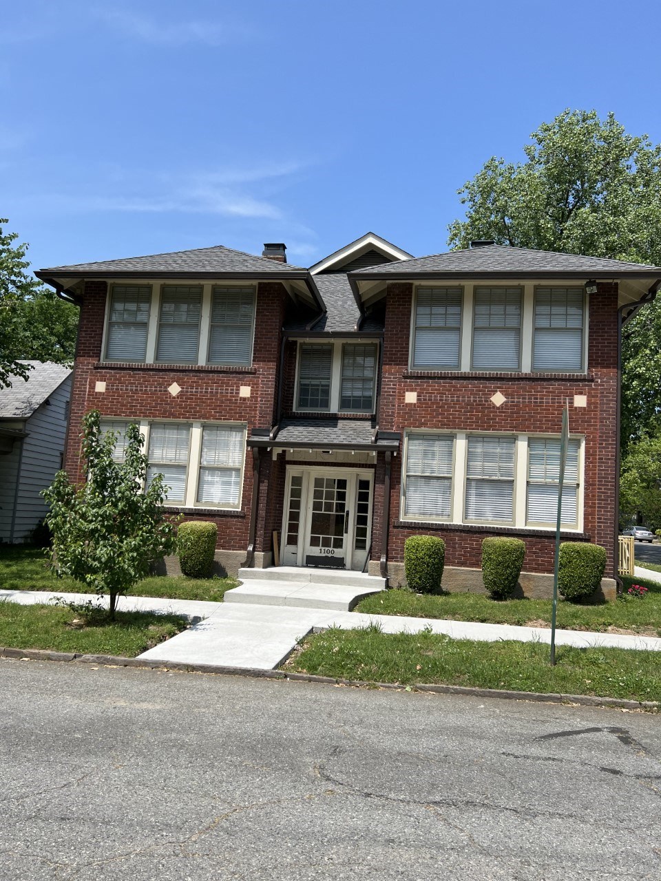 a brick house with a sidewalk in front of it