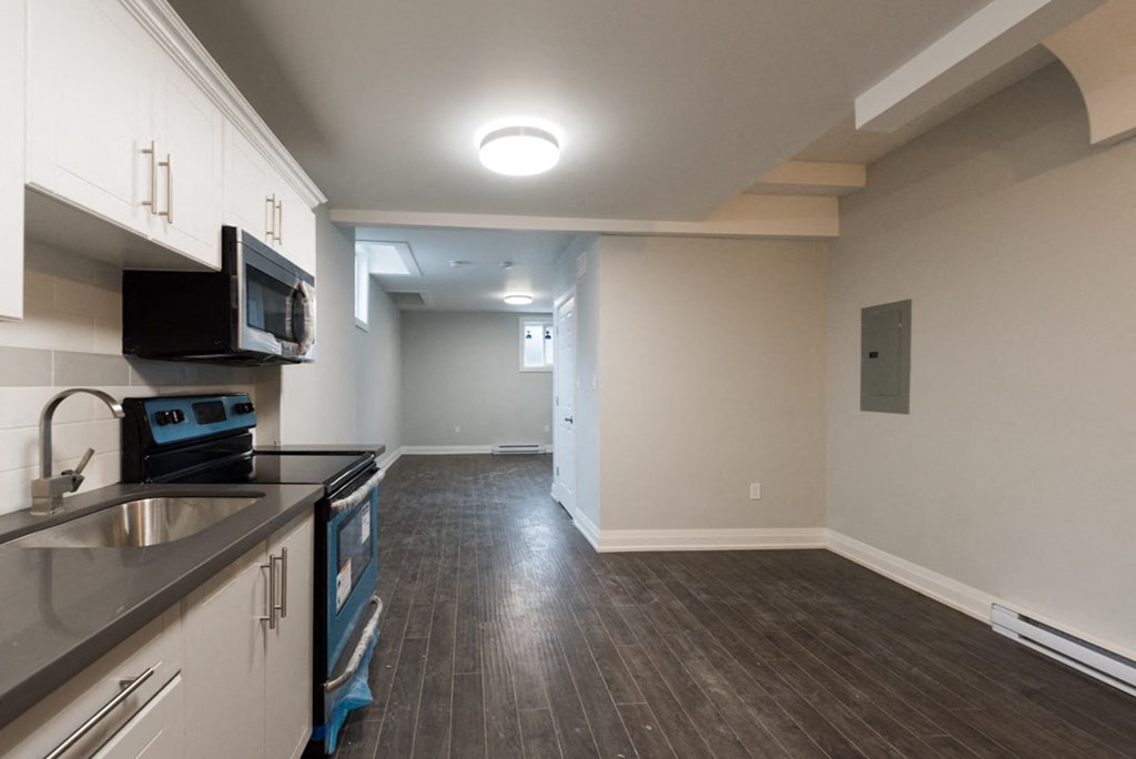 A kitchen with a black microwave above the stove.