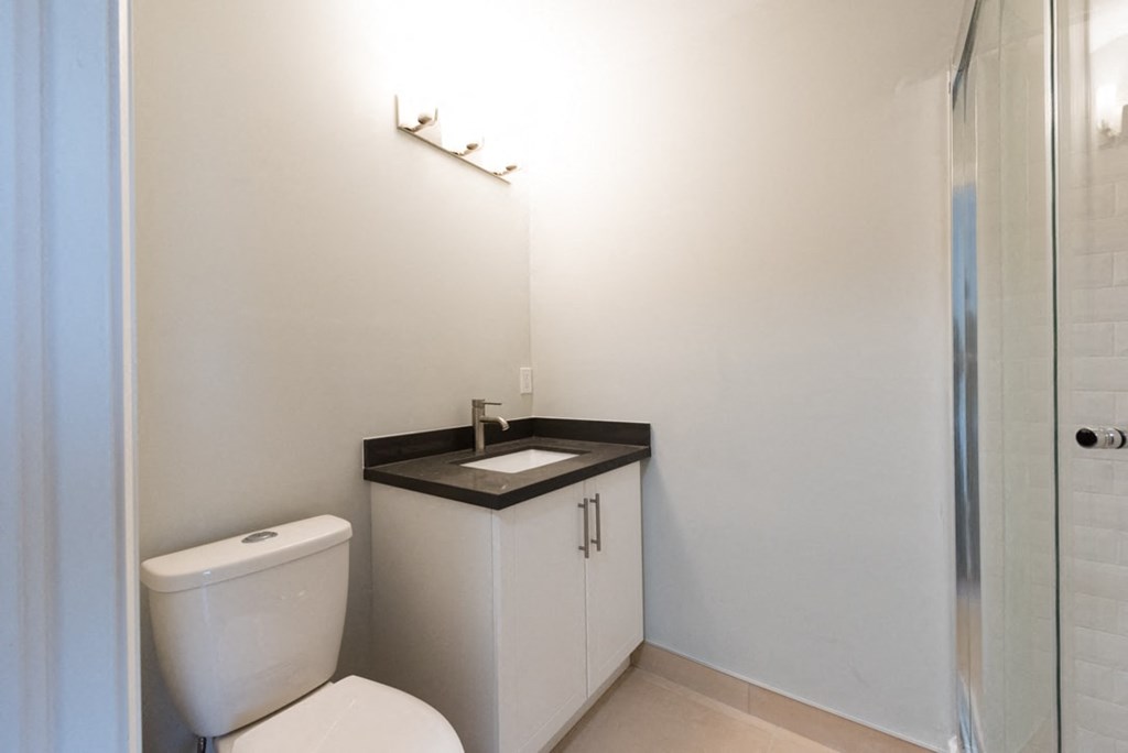 A white toilet sits next to a sink in a small bathroom.