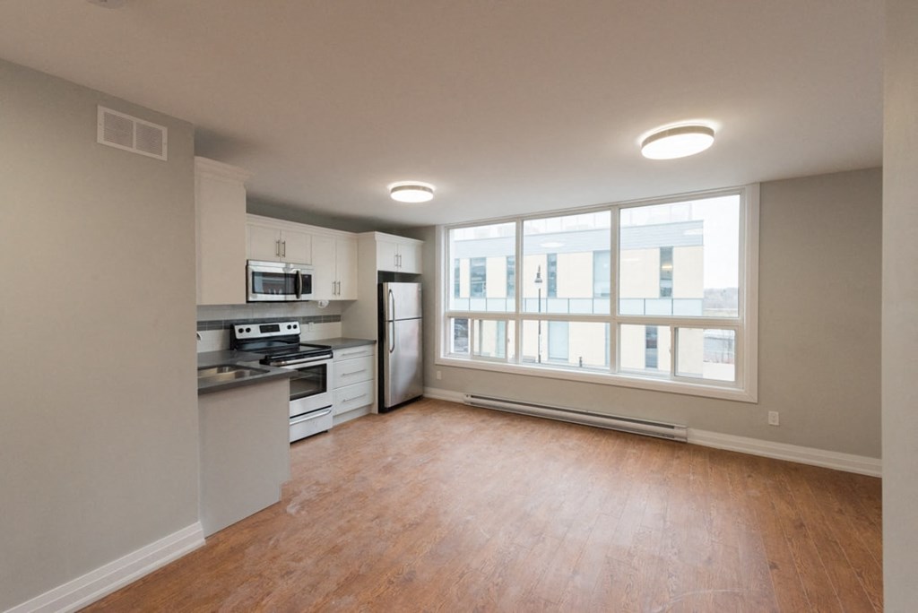 A kitchen with a stove top oven and a refrigerator.