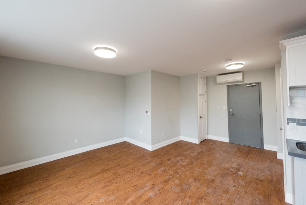 Empty room with wood flooring and white walls.
