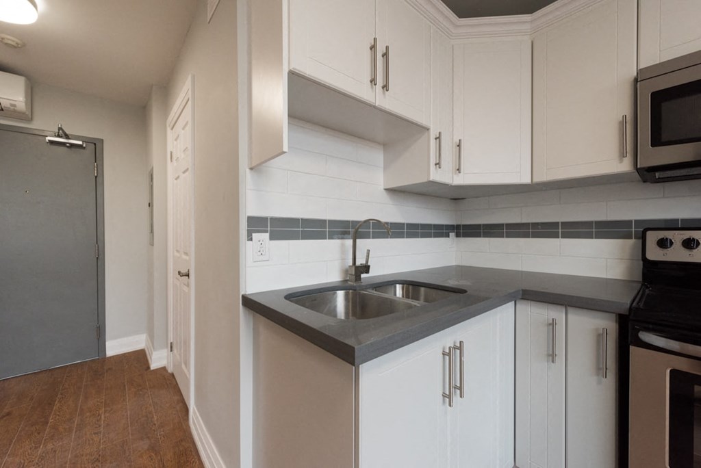 A kitchen with white cabinets and a black stove top oven.