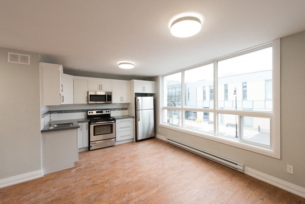 A kitchen with a refrigerator, oven, and microwave.