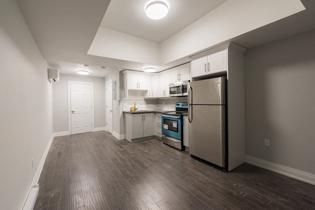 A kitchen with a refrigerator, oven, and microwave.