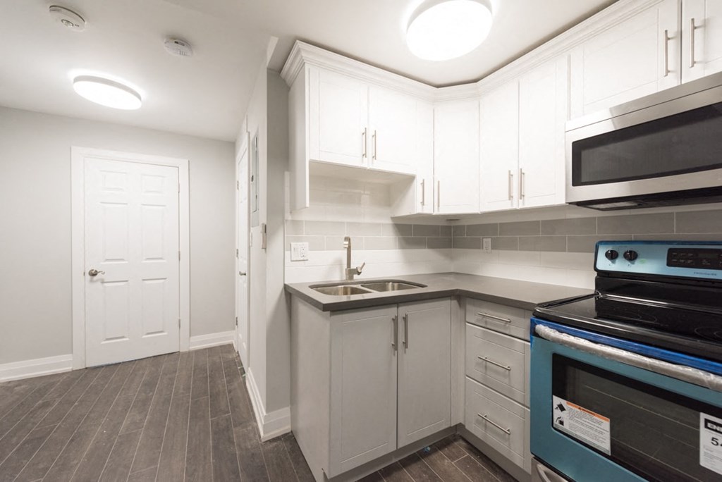 A kitchen with white cabinets and a black stove top oven.