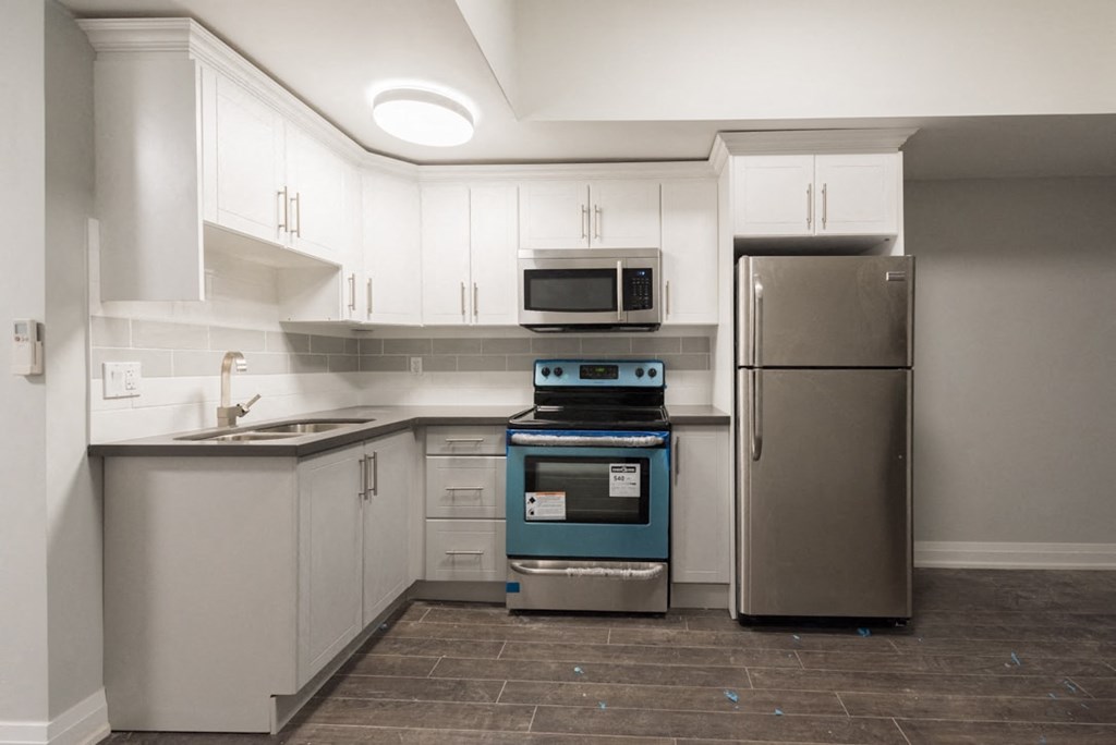 A kitchen with a blue oven and a stainless steel refrigerator.