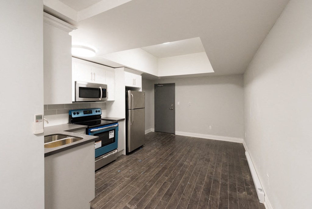 A kitchen with a refrigerator, sink, and microwave.