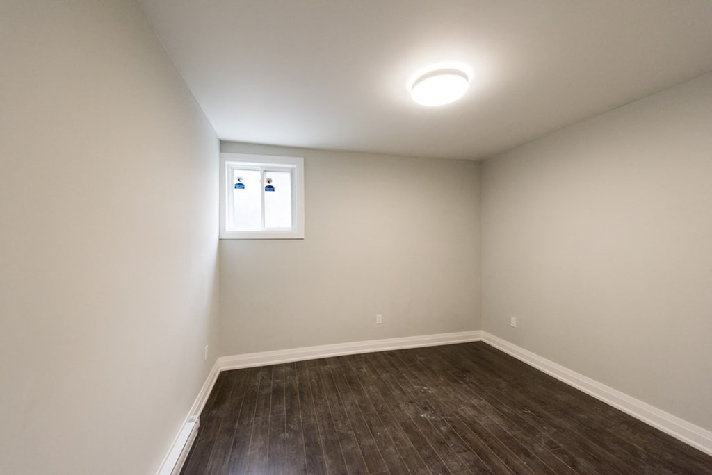 A room with a window and a wooden floor.