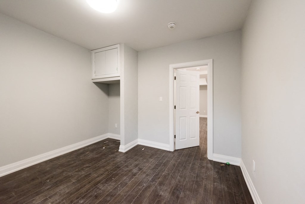 A room with a wooden floor and a white door.