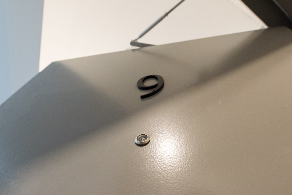 A grey surface with a black number 9 and a small round button.
