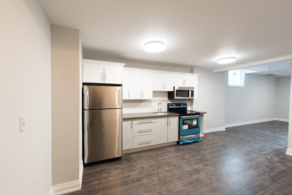 A kitchen with a stainless steel refrigerator and a blue dishwasher.