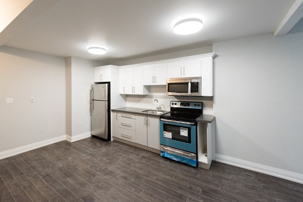 A kitchen with a refrigerator, oven, and microwave.