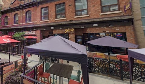 the outside of a restaurant with umbrellas and tables