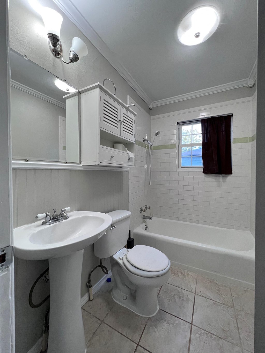A white bathroom with a toilet, sink, and bathtub.