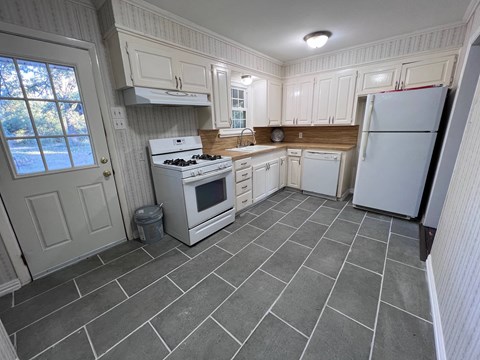 A kitchen with a white stove and a white refrigerator.