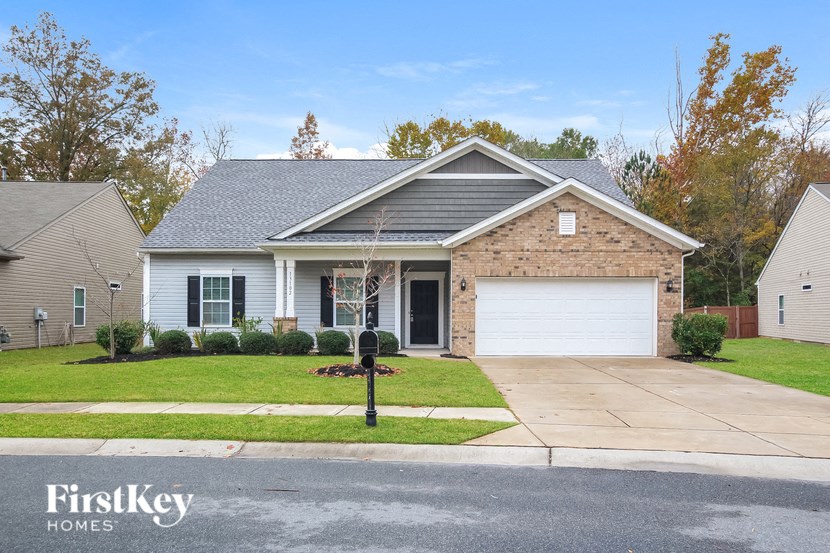 A house with a grey roof and a white garage door is shown.