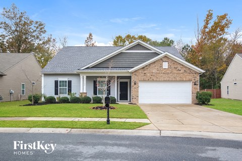 A house with a grey roof and a white garage door is shown.