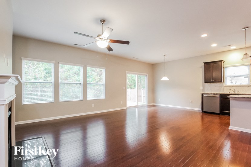 A spacious room with a ceiling fan and wooden flooring.