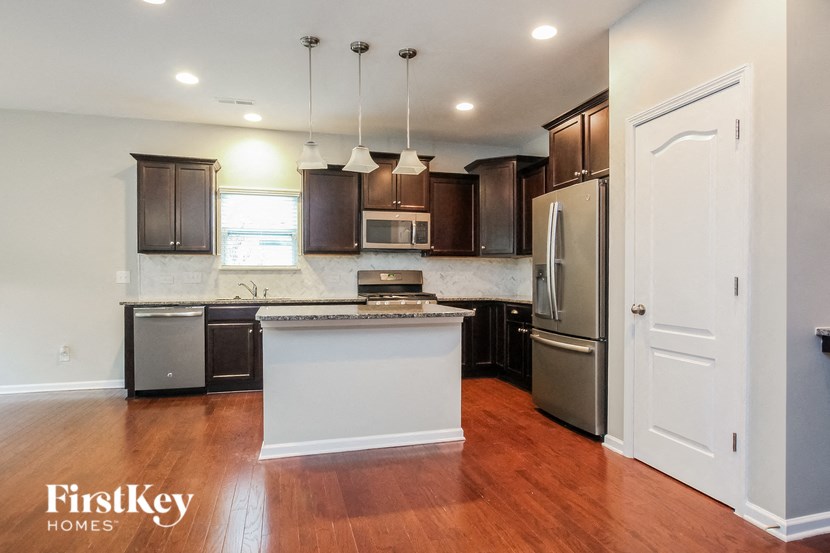 A kitchen with wooden floors and a white island.
