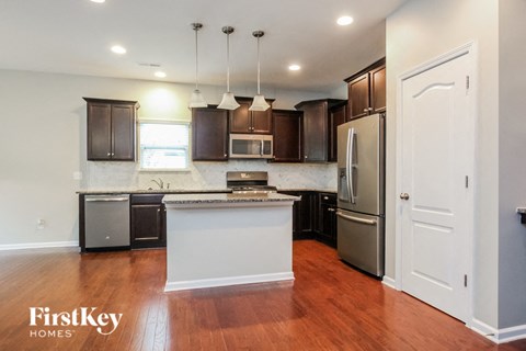 A kitchen with wooden floors and a white island.