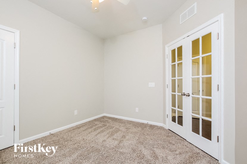 A room with a carpeted floor and a door on the right.