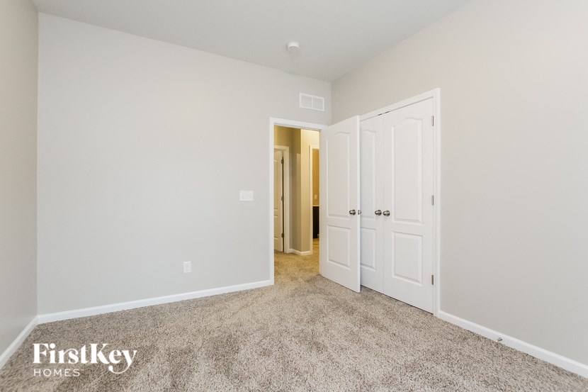 A carpeted room with a door on the right and a wall on the left.