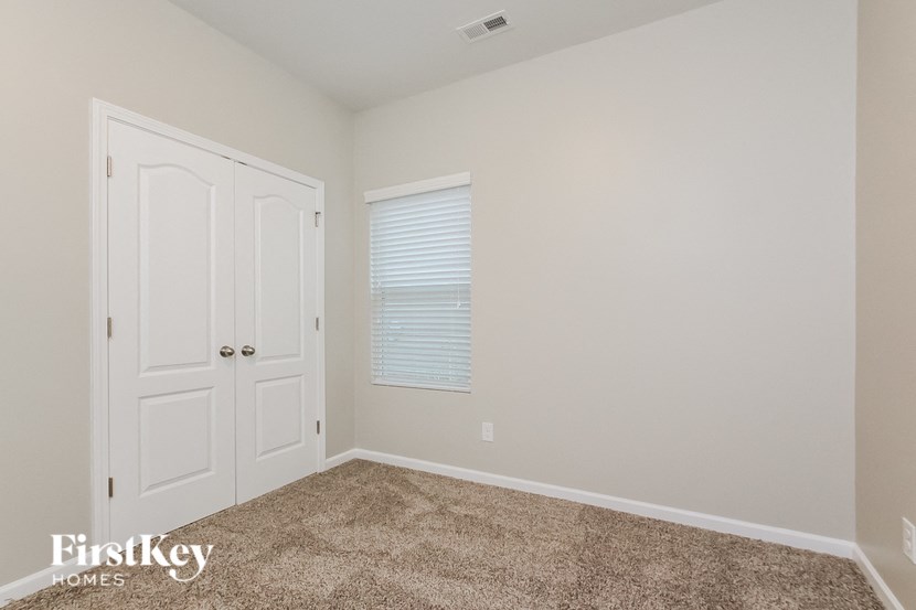 A room with a carpeted floor and a white door.