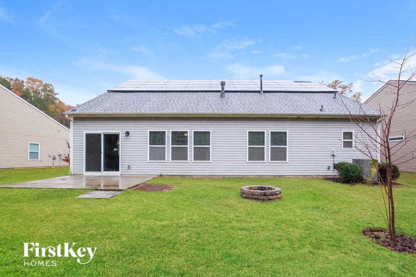 A house with a white siding and a grey roof is shown with a FirstKey Homes logo in the bottom left corner.