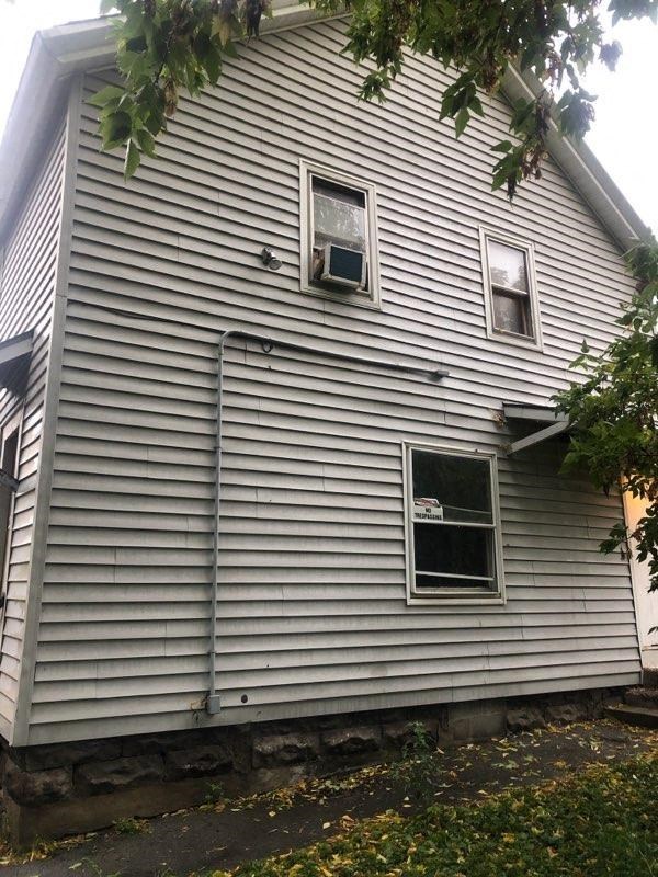 a white house with two windows on the side of it