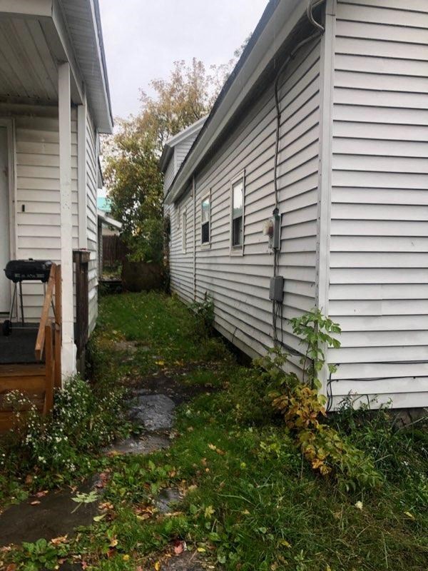 the side of a white house with a path next to it