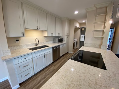 A kitchen with white cabinets and a sink.
