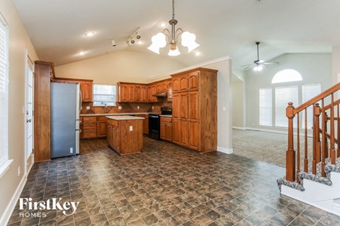 A kitchen with wooden cabinets and a tile floor.