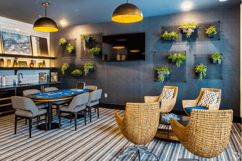 a clubhouse with a poker table and chairs and plants on the wall