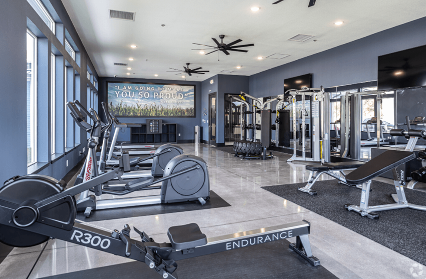 a gym with weights and other exercise equipment and windows