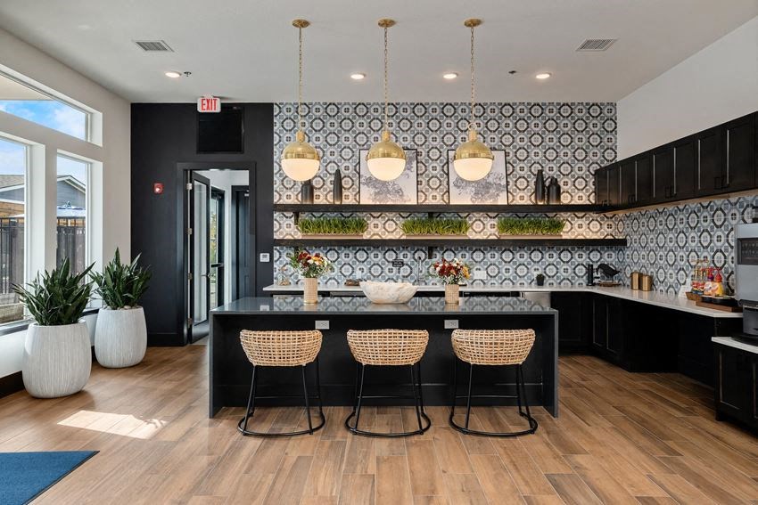 a kitchen with a large island with four chairs