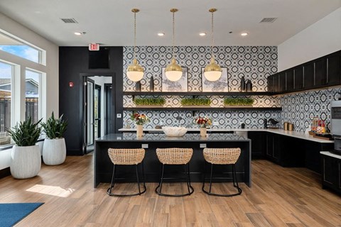 a kitchen with a large island with four chairs