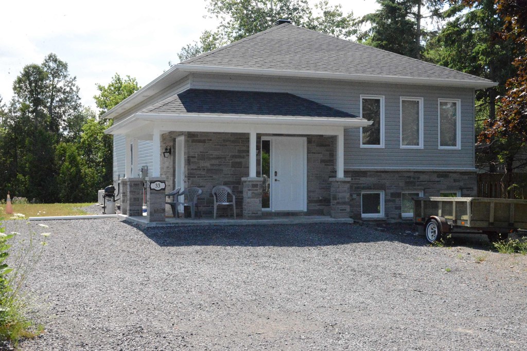 A house with a gravel driveway in front.