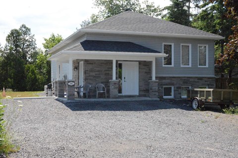 A house with a gravel driveway in front.