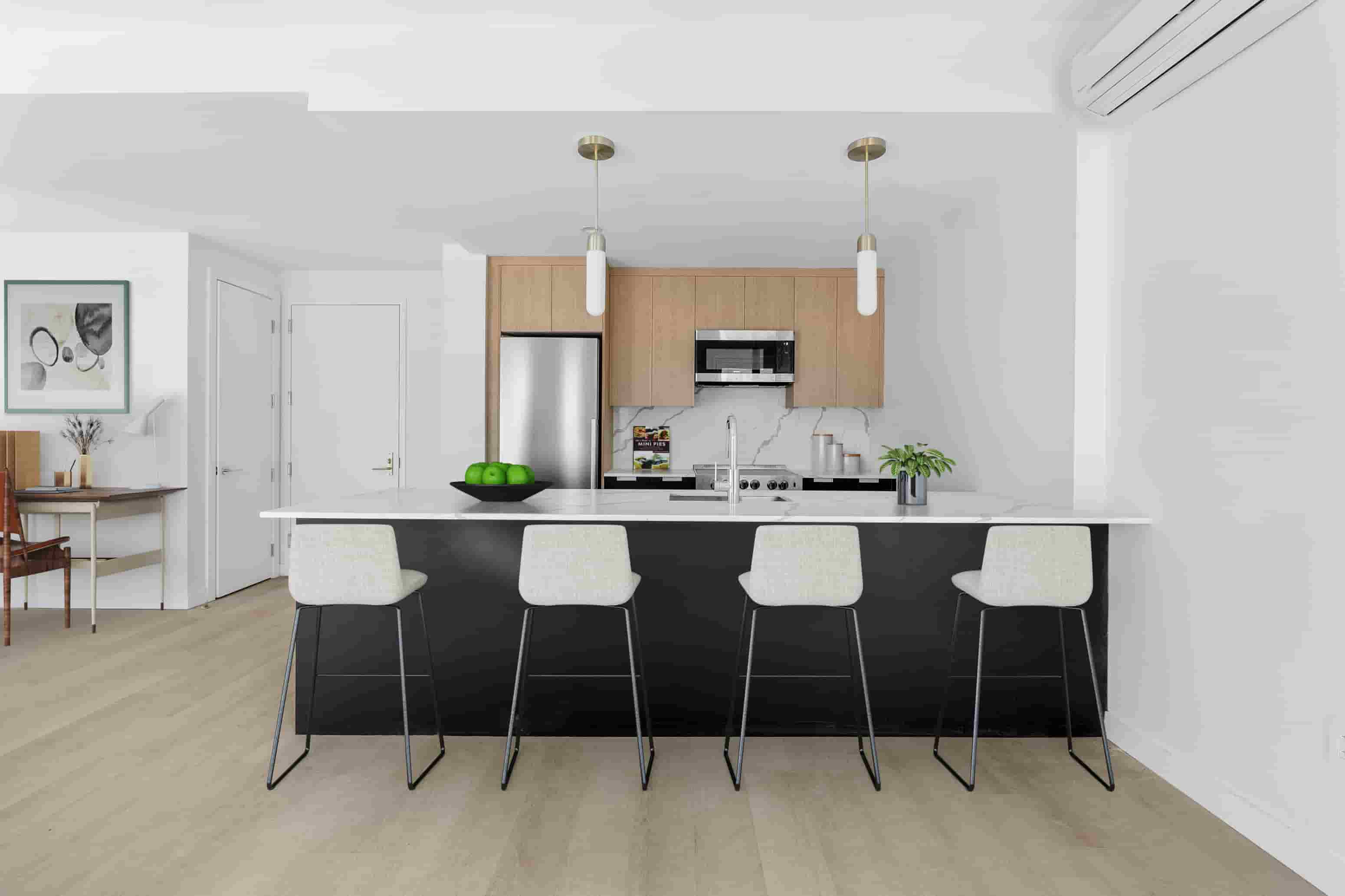 A modern kitchen with a white countertop and black bar stools.