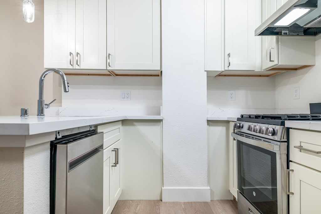 a kitchen with white cabinets and stainless steel appliances