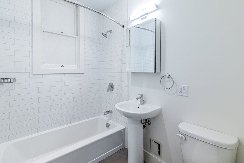 a white bathroom with a sink toilet and bath tub