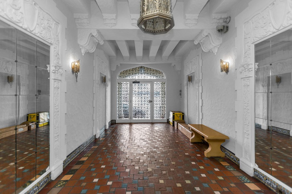 the entrance hall of the building has a large door and a bench
