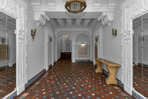 A hallway with white walls and a tiled floor.