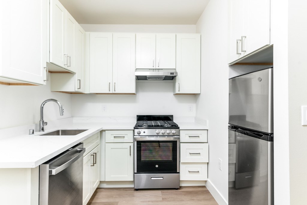a kitchen with white appliances and granite counter tops and wooden cabinets