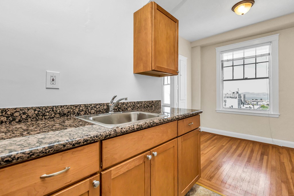 a kitchen with wood cabinets and granite counter tops and a sink