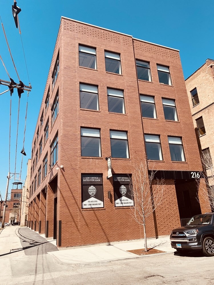 a tall brick building with a car parked in front of it