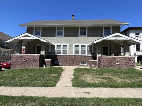 a large house with a sidewalk in front of it