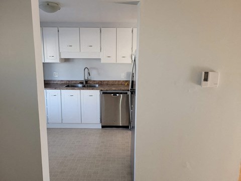 a kitchen with white cabinets and stainless steel appliances